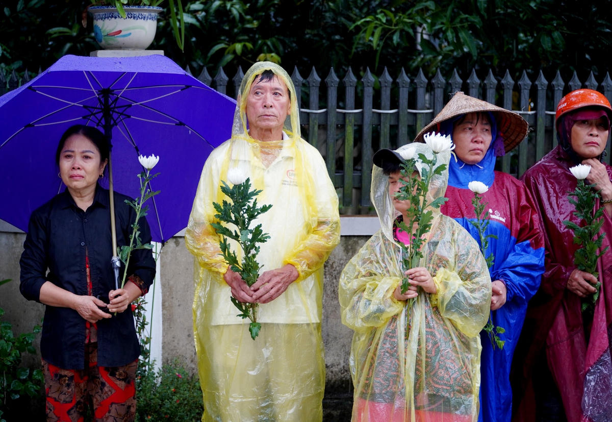 Cơn mưa nặng hạt không cản được những bước chân của người thân, anh em và bà con xóm giềng đưa tiễn người chiến sĩ trẻ.