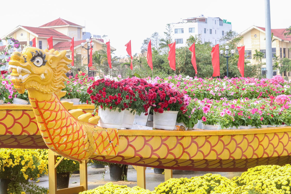 Cụm tiểu cảnh được trang trí bằng thuyền rồng và hoa tươi.