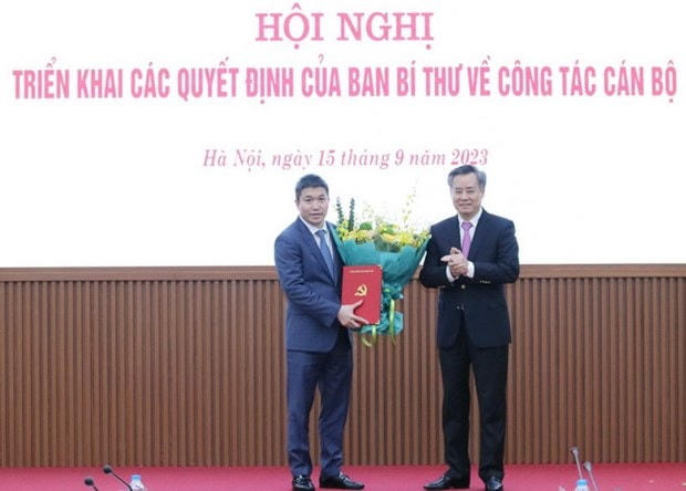 Ông Nguyễn Quang Dương, Phó Trưởng Ban Tổ chức Trung ương trao Quyết định và tặng hoa chúc mừng ông Phan Anh Sơn. (Nguồn: Liên hiệp các tổ chức Hữu nghị Việt Nam).