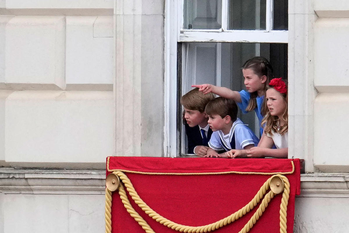 Các hoàng tử và công chúa là cháu chắt của Nữ hoàng Elizabeth II tò mò ngắm khung cảnh bên ngoài Điện Buckingham. Ảnh: Reuters.