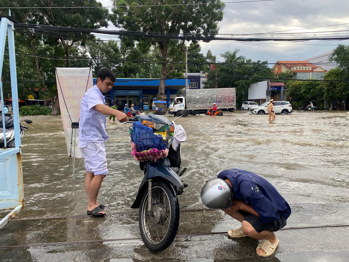 Đội sửa xe miễn phí của một cửa hàng bán xe máy có mặt tại các điểm ngập để giúp đỡ các trường hợp xe bị chết máy.