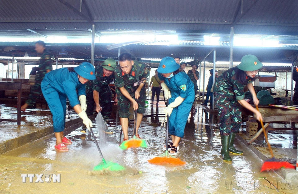Lực lượng Quân đội, dân quân tự vệ dọn vệ sinh, khắc phục hậu quả do mưa lũ gây ra tại chợ xã Thanh Mỹ, huyện Thanh Chương, tỉnh Nghệ An, tháng 10/2022. (Ảnh: Tá Chuyên/TTXVN)