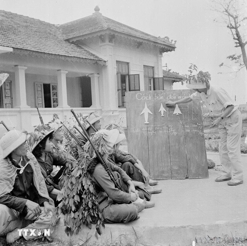 Đồng chí Nguyễn Xuân Tảo, bộ đội phục viên, trung đội trưởng đội dân quân tự vệ bệnh viện Hà Đông chia sẻ kinh nghiệm bắn máy bay cho tổ săn máy bay của bệnh viện. (Ảnh: Thanh Tụng/TTXVN)