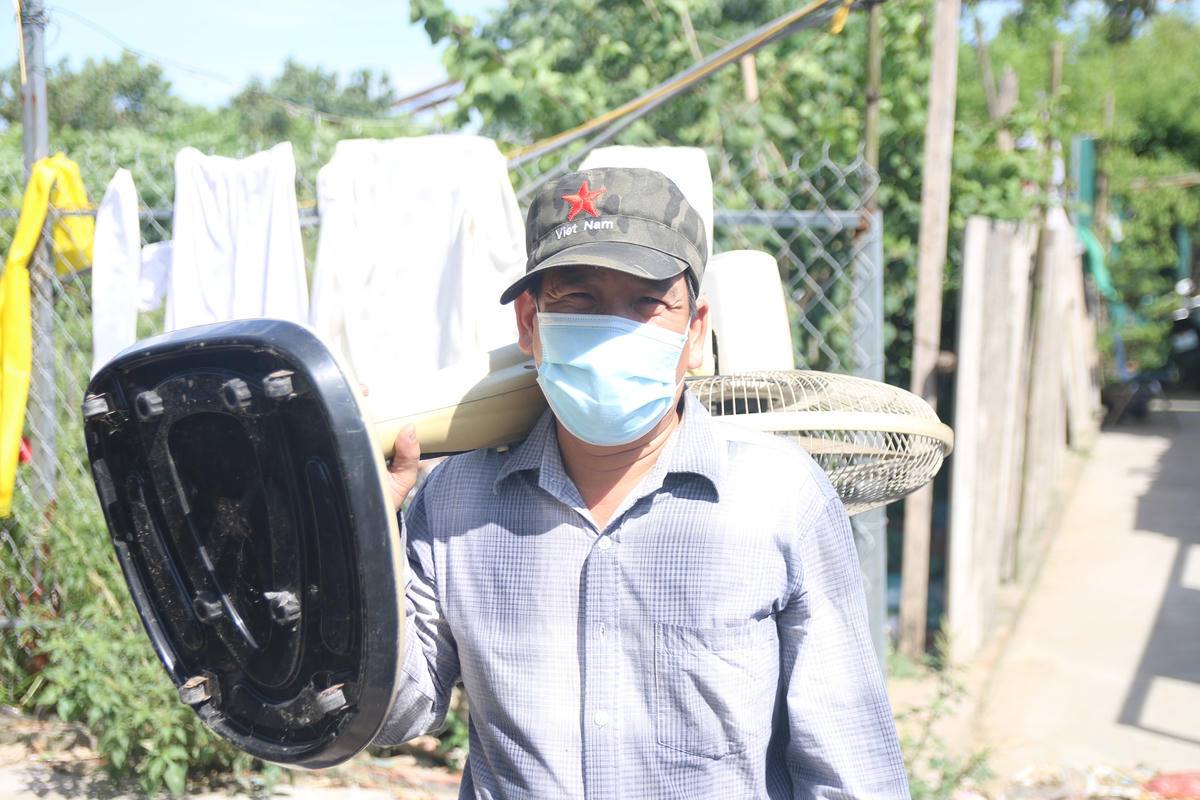 Trời nắng như đổ lửa, ông Mạnh (người dân sống tại xóm trọ nghèo trong ngõ 127 Phúc Xá) mang quạt đi sửa chữa.