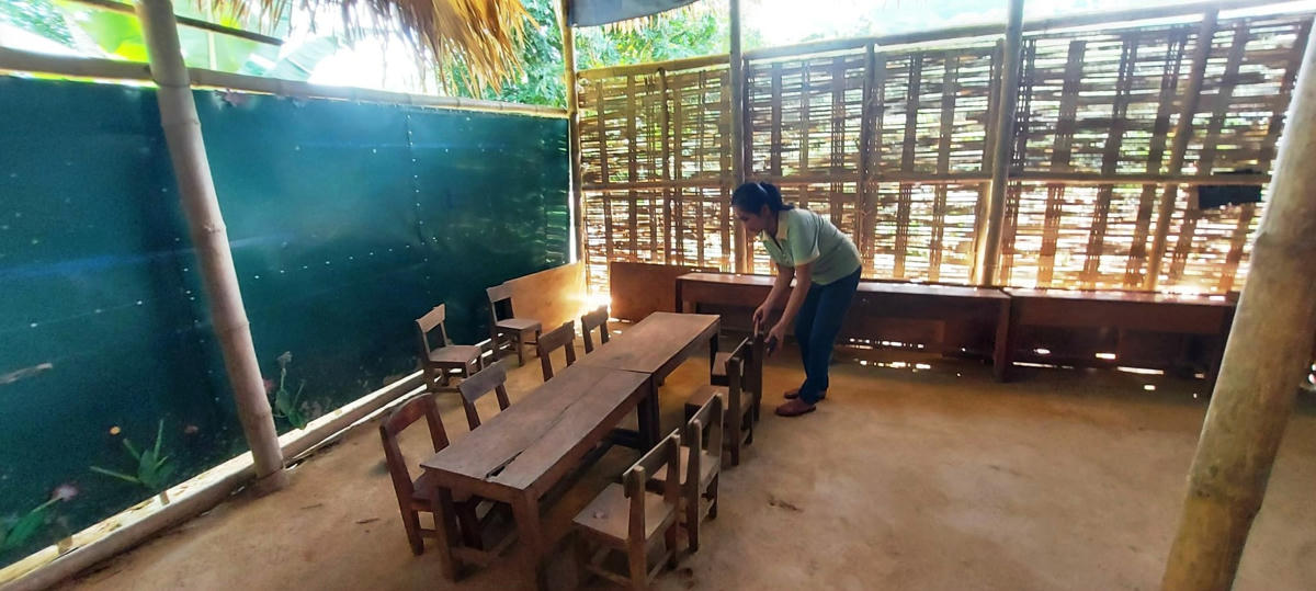 Người dân bản cùng các giáo viên gia cố lại lớp học tranh tre cho năm học mới.  