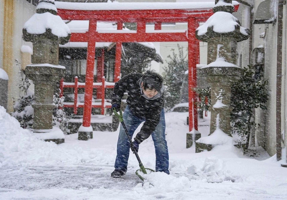 Một người xúc tuyết trước một ngôi đền ở Tottori, phía tây Nhật Bản. Ảnh: Kyodo/AP.