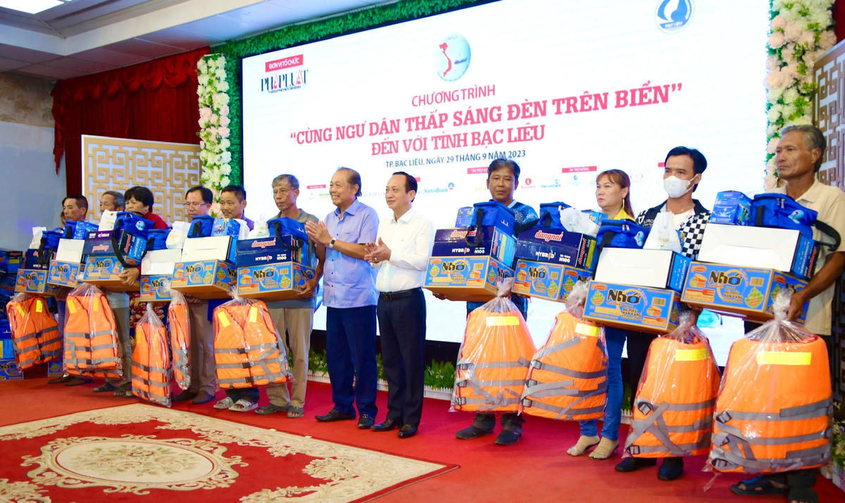 Nguyên Phó Thủ tướng Thường trực Trương Hoà Bình và ông Phạm Văn Thiều, Chủ tịch UBND tỉnh Bạc Liêu trao  quà tặng cho bà con ngư dân.