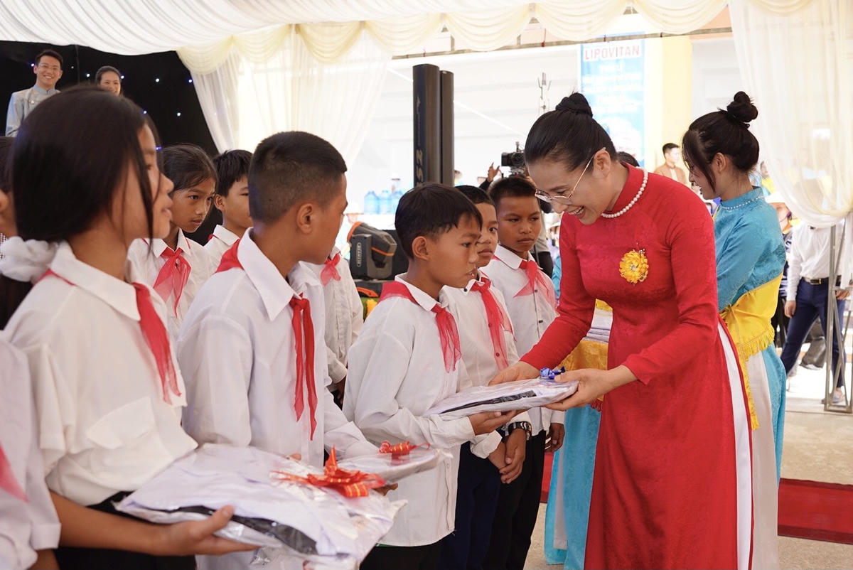 Phật tử Phạm Thị Yến - đại diện CLB Cúc Vàng trao quà đến các em học sinh.