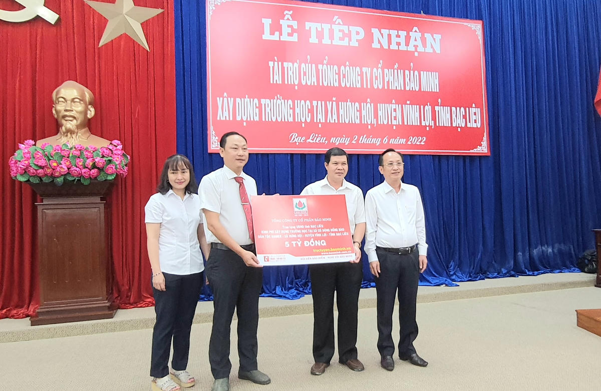 Đại diện Tổng công ty Cổ phần Bảo Minh trao bảng tượng trưng kinh phí 5 tỷ đồng tài trợ để xây dựng trường học ở xã Hưng Hội, huyện Vĩnh Lợi.