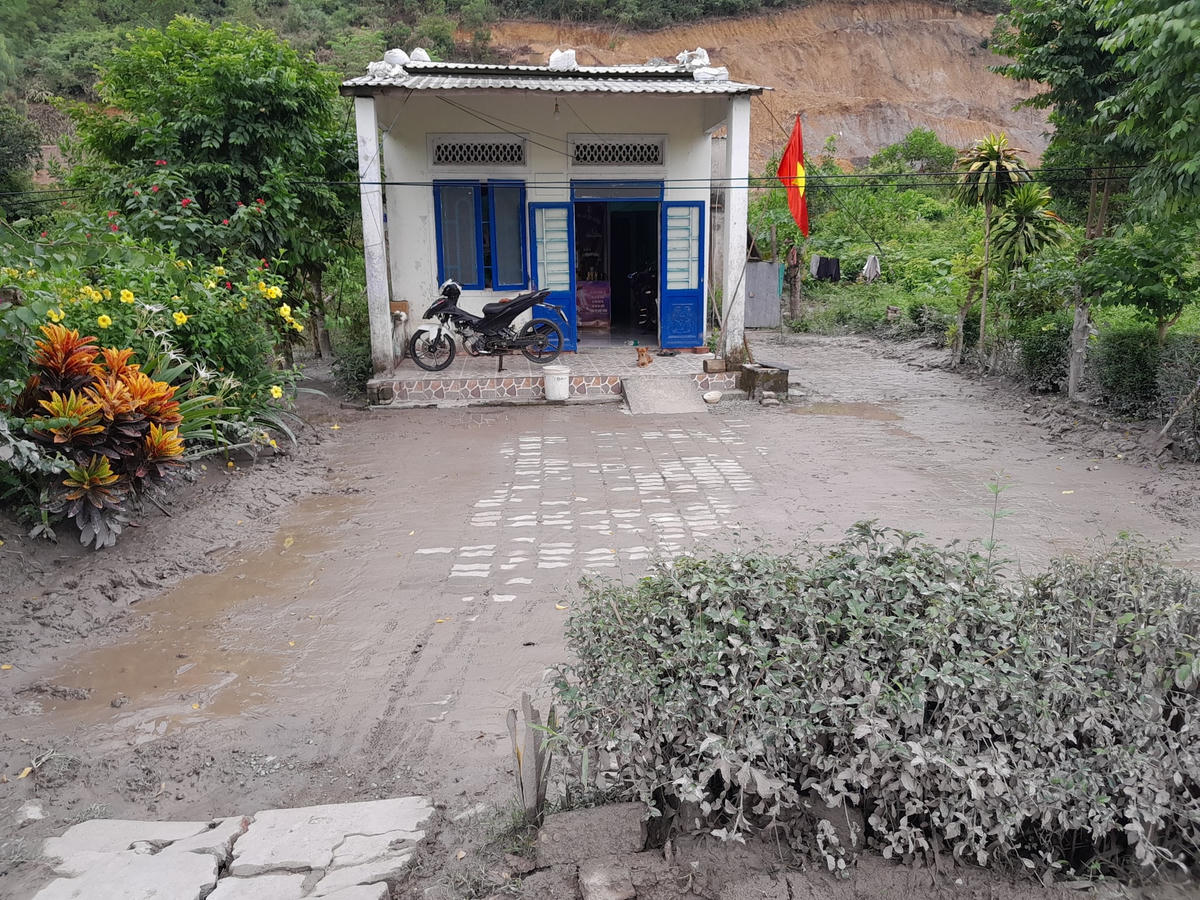 Bùn, đất tràn vào sân, vườn nhà dân sau mỗi trận mưa lớn. Ảnh: Ủy ban MTTQ huyện Hòa Vang.