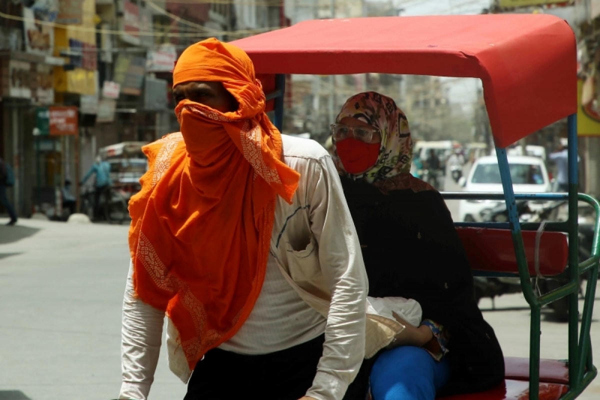 Một người chạy xe tuk tuk tại thủ đô New Delhi (Ấn Độ) quấn khăn để tránh cái nóng lên tới 44 độ C. Ảnh: ANI.