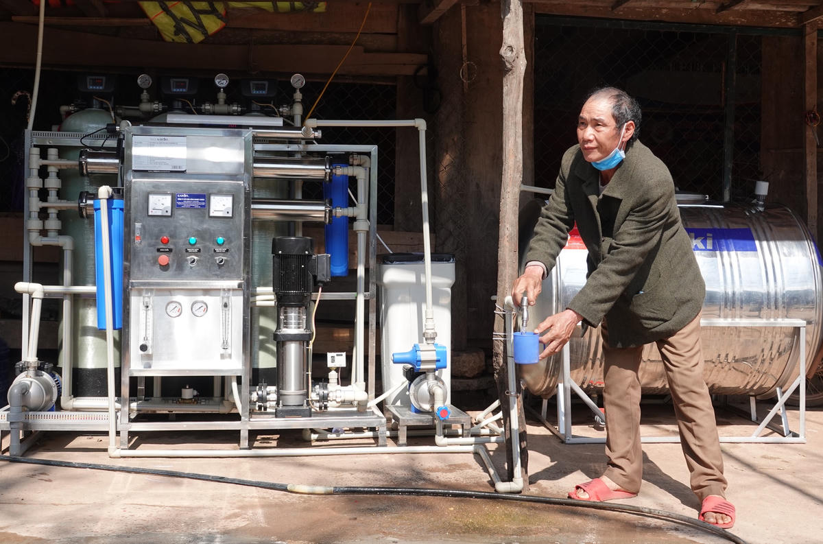 Ông Cao Xuân Xiêm bên máy nước sinh hoạt phục vụ người dân ở bản Ka Ai.