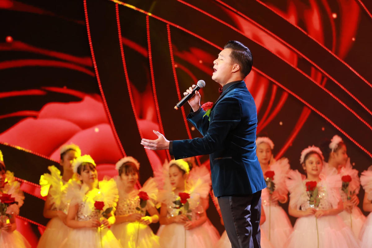Ca sĩ Quang Dũng thể hiện ca khúc "Bông hồng cài áo" trong hoạt cảnh "Mùa hiếu hạnh" mở đầu chương trình.