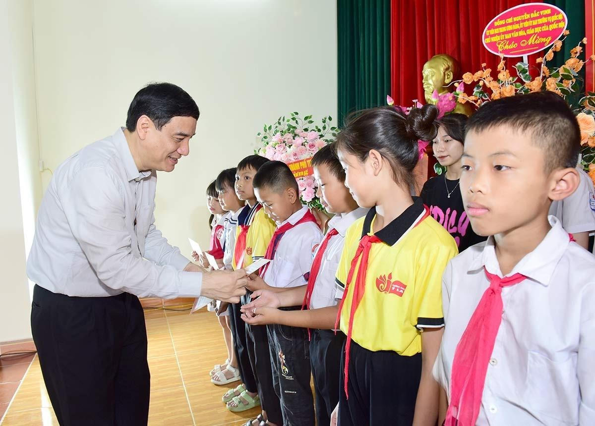 Chủ nhiệm Ủy ban Văn hóa, Giáo dục của Quốc hội Nguyễn Đắc Vinh trao học bổng cho học sinh, sinh viên vượt khó vươn lên trong học tập. Ảnh: Huy Hoàng.