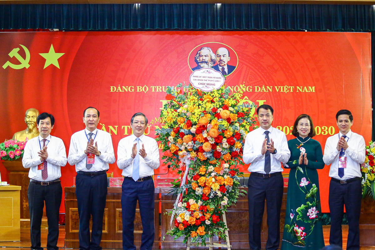 Ông Ngô Văn Cương, Phó Bí thư Đảng ủy MTTQ, các đoàn thể Trung ương tặng hoa chúc mừng Ban Thường vụ Đảng ủy Trung ương Hội Nông dân Việt Nam. Ảnh: Quang Vinh