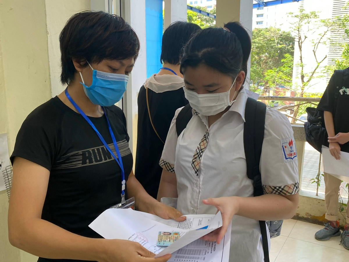 Cán bộ coi thi kiểm tra thông tin thí sinh tại kỳ thi vào lớp 10 tại Hà Nội năm 2022.