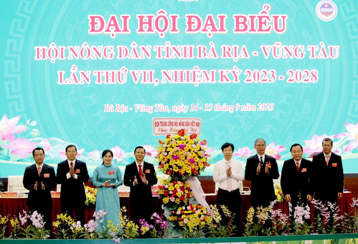 Ông Nguyễn Xuân Định, Phó Chủ tịch Trung ương Hội Nông dân Việt Nam (áo trắng) tặng hoa chúc mừng Đại hội.