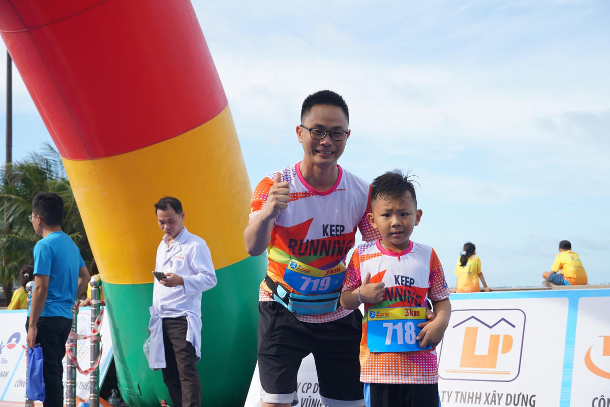 Hai VĐV là bố con vui mừng sau khi kết thúc cự ly 3km. Ảnh: Mạnh Thìn.