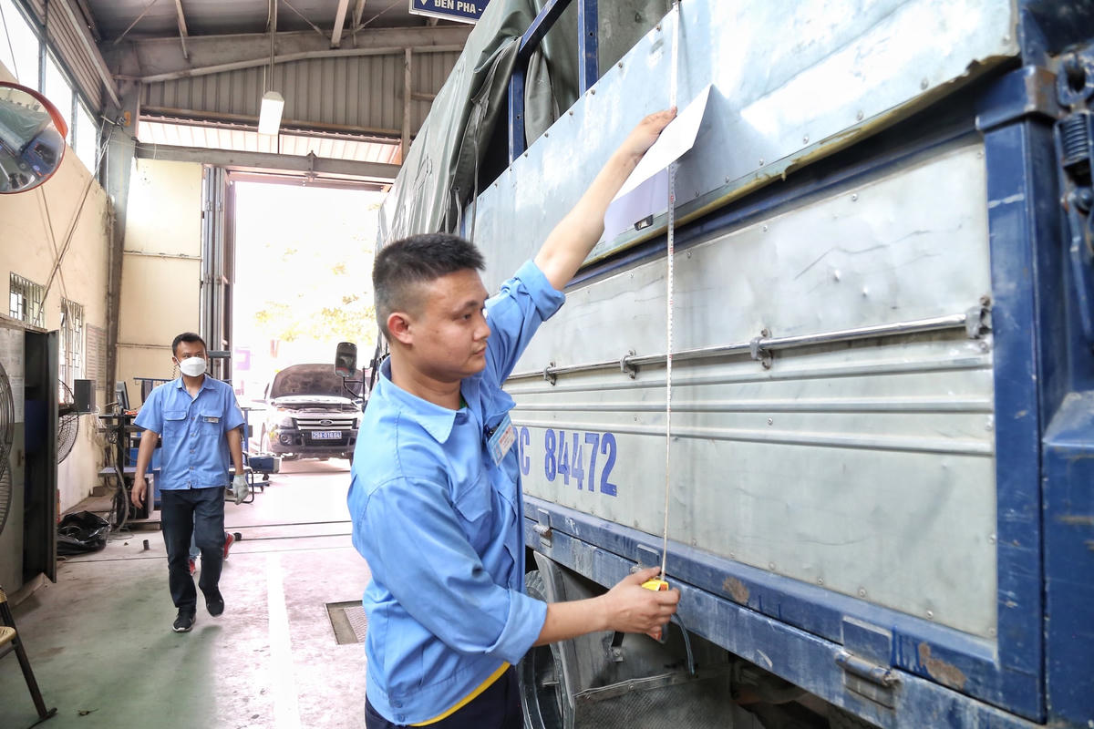 Đăng kiểm viên đo kích thước thùng xe tải.