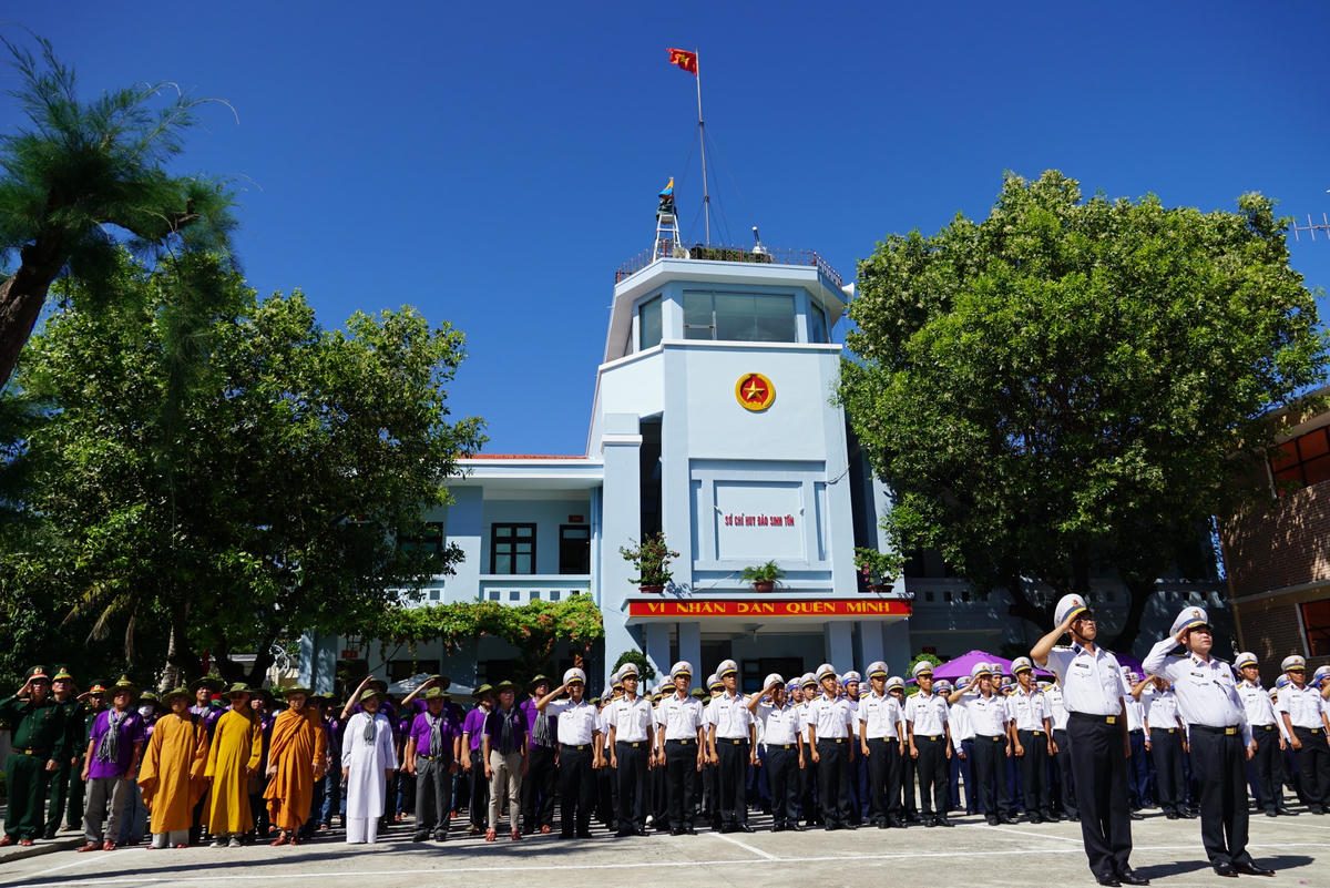 Đoàn công tác cùng cán bộ, chiến sĩ, nhân dân thực hiện nghi thức Chào cờ tại đảo Sinh Tồn. Ảnh: Mạnh Thìn.