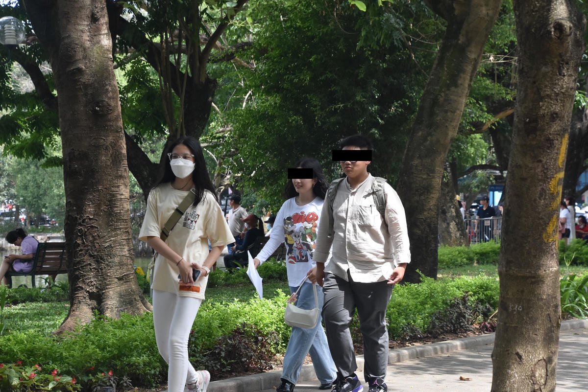 Thản nhiên tản bộ từng nhóm mà không đeo khẩu trang...