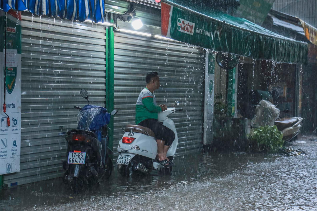 Do mưa lớn xảy ra úng ngập, nhiều người dân tấp vào lề đường để tránh xe bị chết máy.