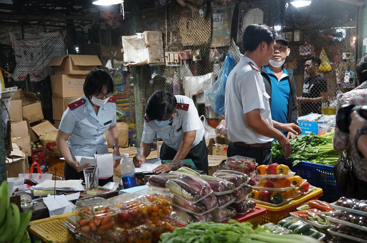 Cơ quan chức năng kiểm tra, truy vết đầu vào nguồn thực phẩm kinh doanh tại một chợ đầu mối ở TPHCM. Ảnh: Hồng Phúc.
