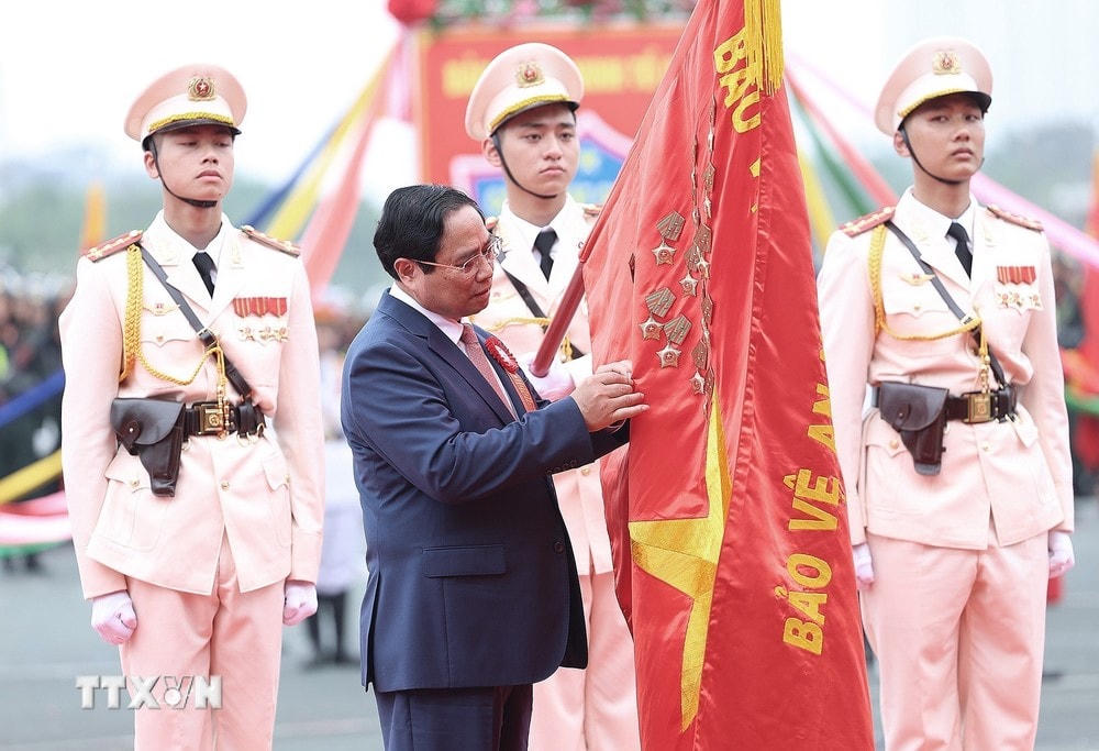 Thủ tướng Phạm Minh Chính gắn Danh hiệu Anh hùng Lực lượng Vũ trang Nhân dân lên cờ truyền thống của lực lượng Cảnh sát Cơ động. (Ảnh: Dương Giang/TTXVN) TTXVN_1404Thutuong10.jpg