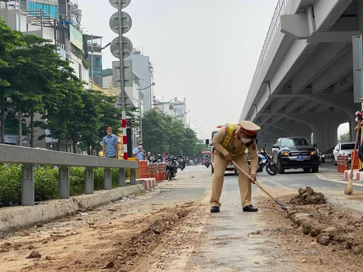 Đất đá phủ kín đường kéo dài hàng trăm mét, lực lượng chức năng đang tiến hành dọn dẹp trả lại mặt đường cho xe ô tô lưu thông.