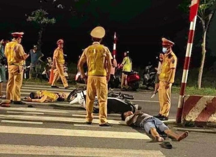 Cú tông mạnh khiến chiến sĩ CSGT đang làm nhiệm vụ bị hất văng ra xa, 2 thanh niên ngồi trên xe máy ngã ra đường (Ảnh: MXH).