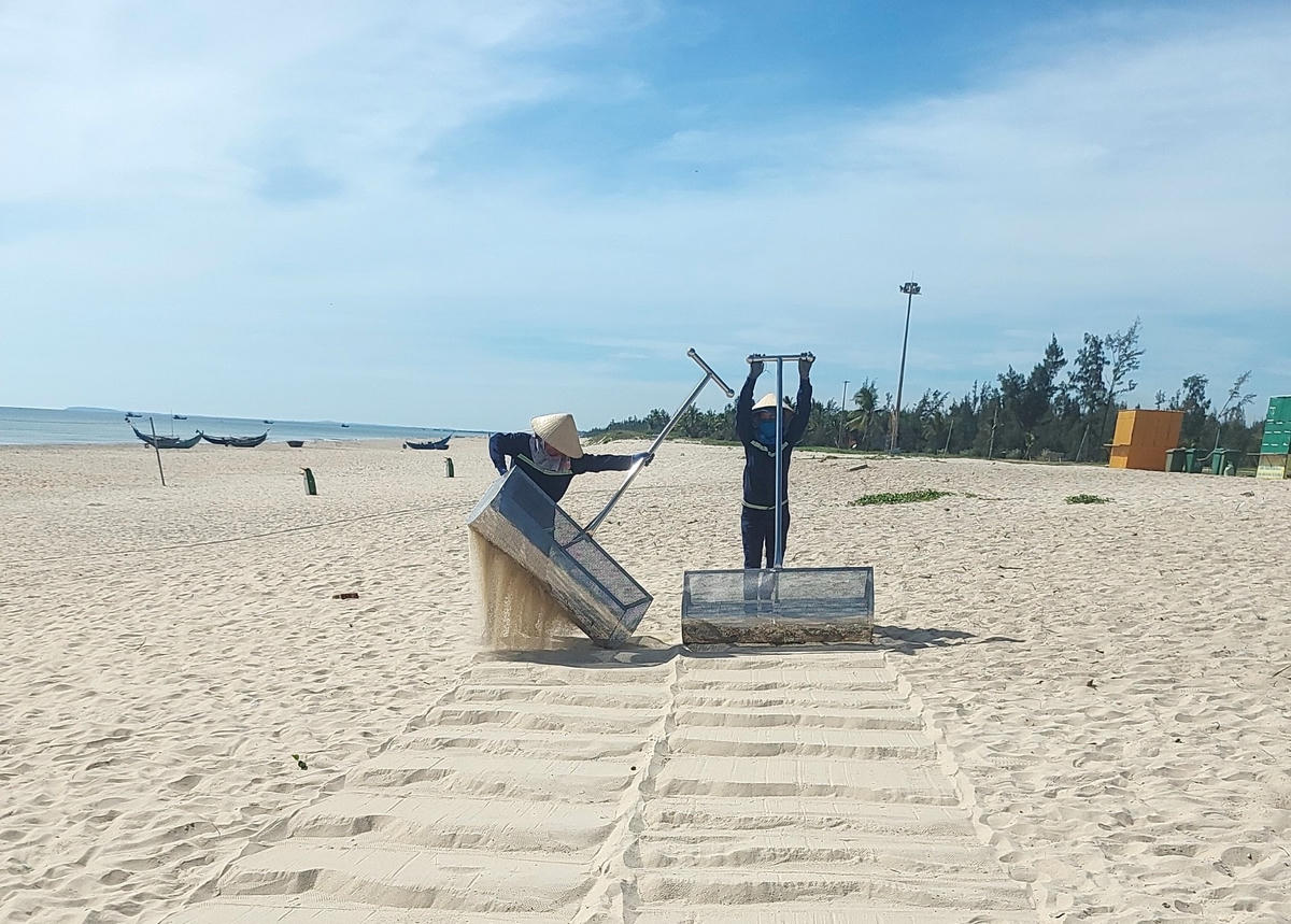 Công nhân thu dọn rác ở bãi tắm Tam Thanh.