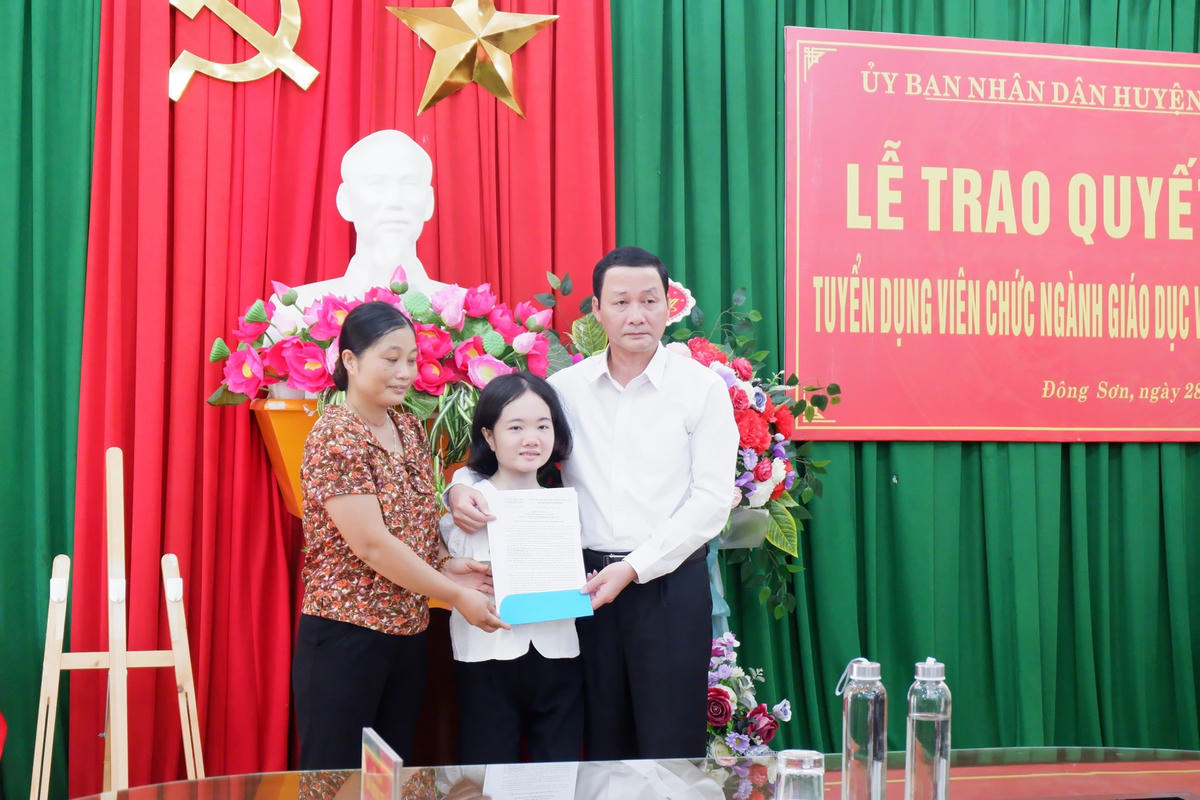 Ông Đỗ Minh Tuấn, Chủ tịch UBND tỉnh Thanh Hóa trao quyết định đặc cách tuyển dụng cho cô giáo Lê Thị Thắm.