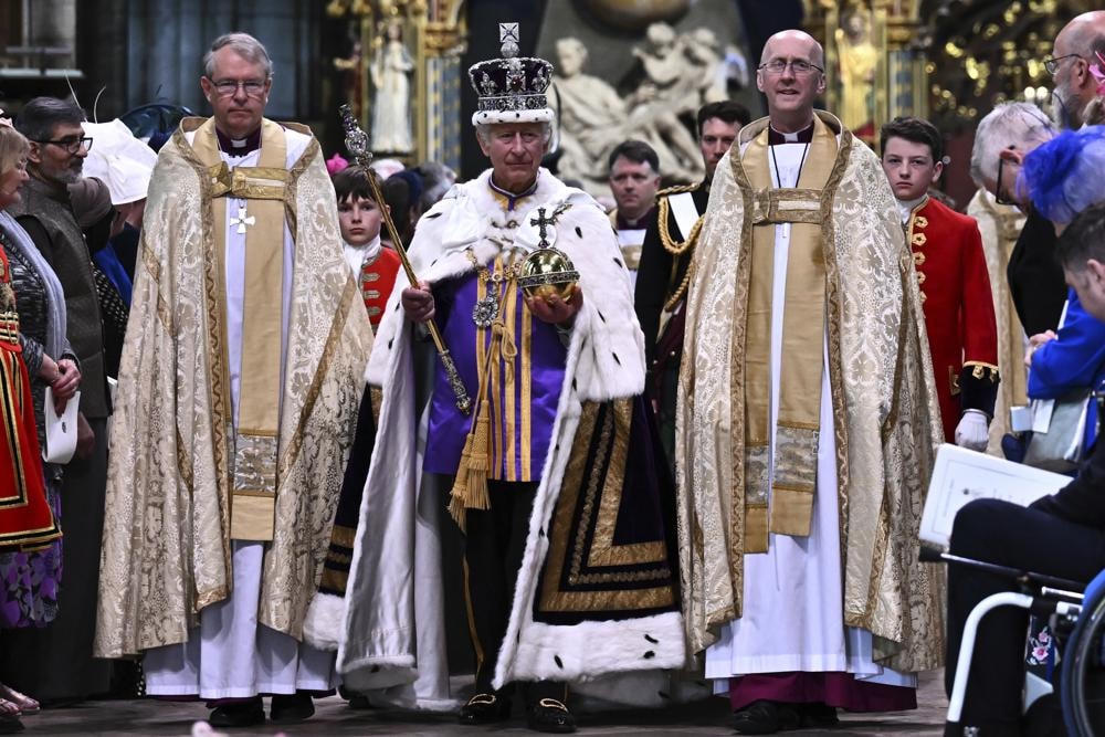 Vua Charles III đội Vương miện của Nhà nước Hoàng gia và mang theo Quả cầu Chủ quyền và Vương trượng rời Tu viện Westminster sau lễ đăng quang.  