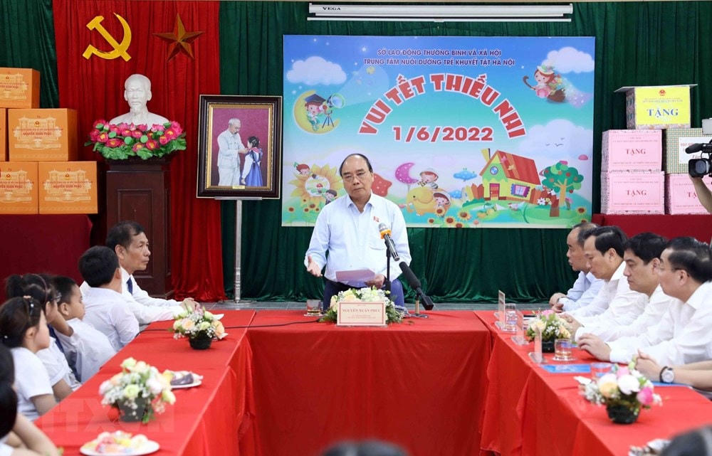 Chủ tịch nước Nguyễn Xuân Phúc động viên các thầy giáo, cô giáo và trẻ khuyết tật tại Trung tâm. (Ảnh: An Đăng/TTXVN).