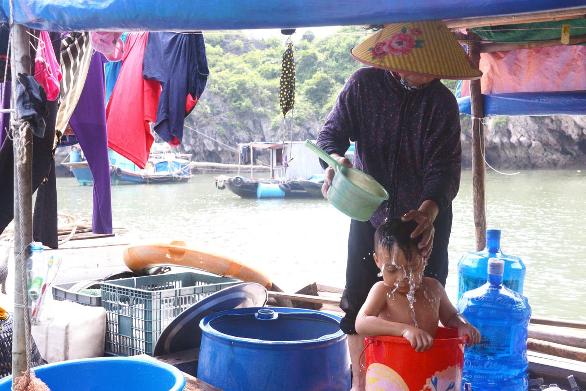 Cậu bé Quyền (5 tuổi) được bà cho ngâm nước vào giữa trưa để chống chọi với cái nóng.