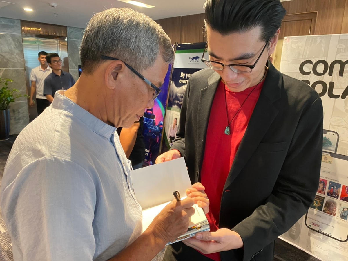 Họa sĩ, tác giả Nguyễn Hùng Lân ký tặng bạn đọc hâm mộ tại buổi lễ.