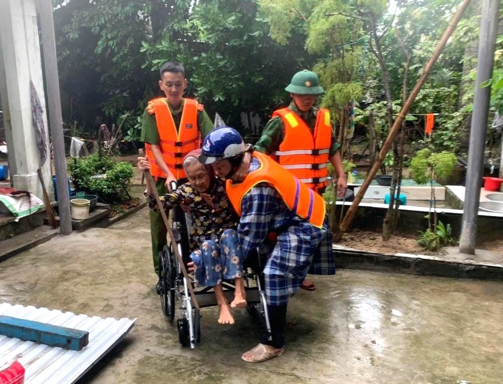 Người già yếu được lực lượng chức năng giúp đỡ đưa đi trú bão.