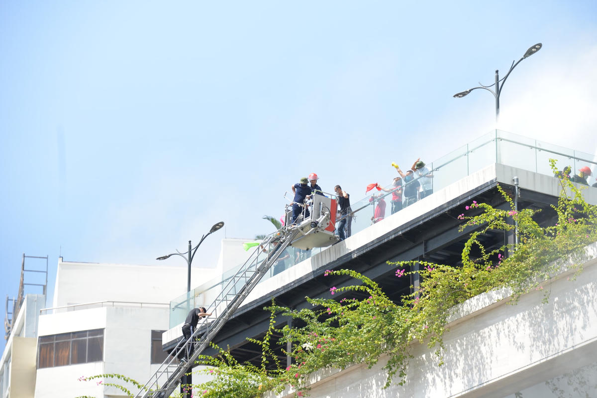 Những người mắc kẹt trên tầng cao được lực lượng chức năng ứng cứu bằng xe thang.