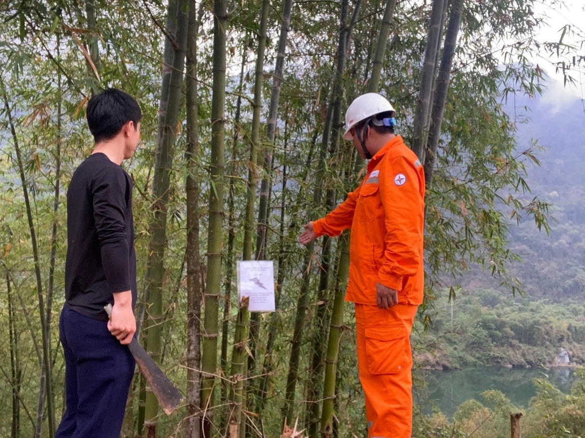 Công nhân Điện lực trực thuộc Công ty Điện lực Thanh Hóa tuyên truyền đến người dân về việc chặt tỉa cây trồng nằm trong phạm vi có nguy cơ gây mất an toàn hành lang lưới điện.