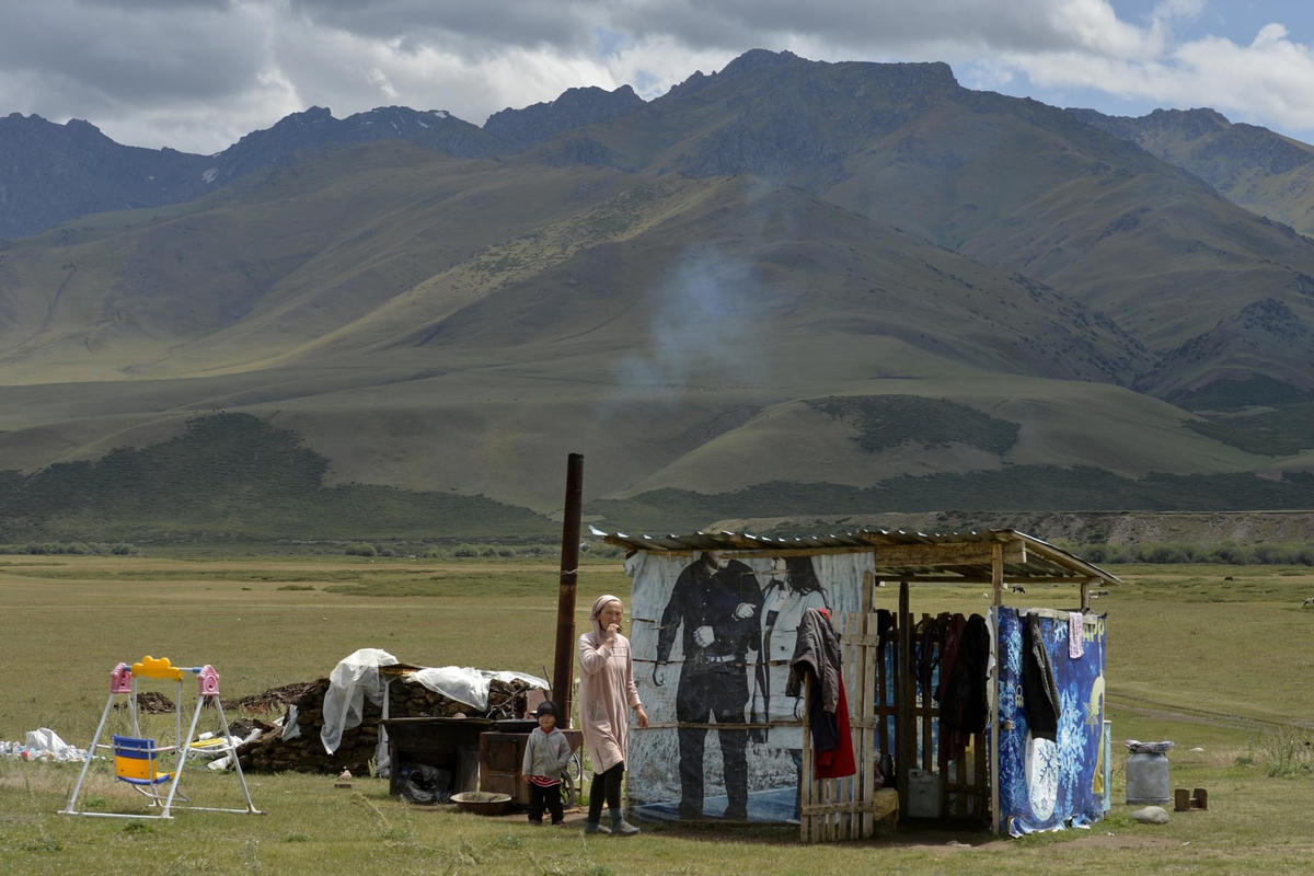 Người dân Kyrgyzstan đi dạo quanh những căn lều và nhà bếp tạm thời trên một đồng cỏ ở Thung lũng Suusamyr.