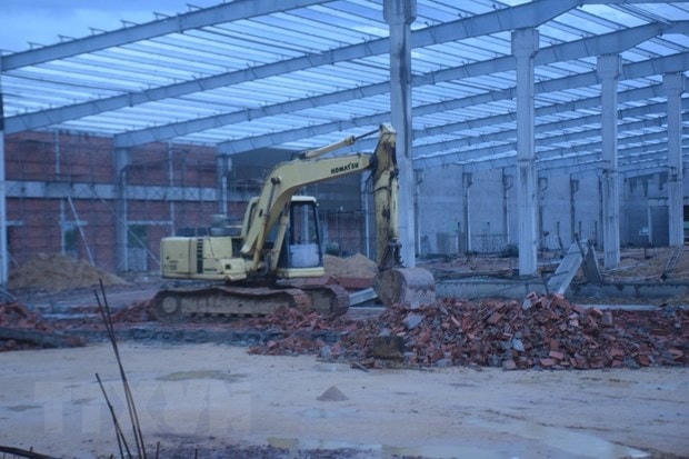 Sử dụng xe máy xúc để tìm kiếm nạn nhân bị chôn vùi sau vụ sập tường. (Ảnh: Sỹ Thắng/TTXVN).