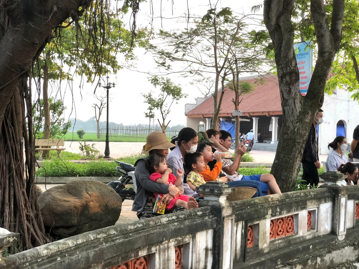 Người dân làng Đào Thục vui vẻ ngồi quanh thủy đình xem diễn rối nước.
