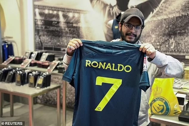 Một CĐV phấn khích khi sở hữu chiếc áo số 7 của Ronaldo ở Al-Nassr (Ảnh: Reuters).