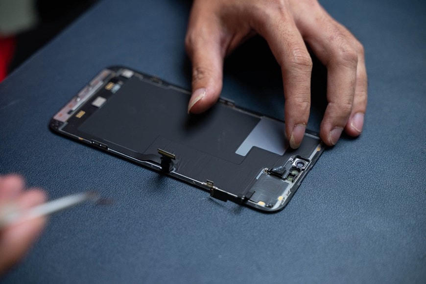 Kỹ thuật viên tháo từng miếng shield và sau đó cách ly pin và mở tháo phần màn hình. Cụm camera, FaceID tiếp tục được tháo từng chân tiếp xúc. Theo đánh giá của kĩ thuật viên, kích thước của cụm Dynamic Island thực chất là phần màn hình OLED được Apple tắt hiển thị pixel. (Ảnh: Điện Thoại Vui).