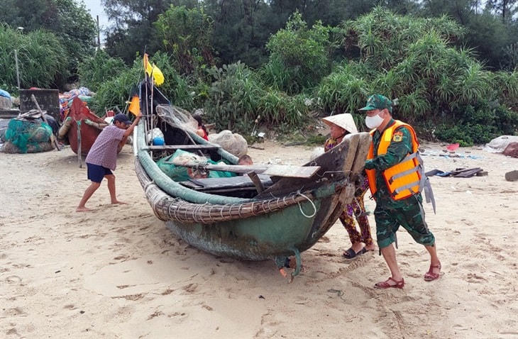 Cán bộ Đồn Biên phòng Vinh Xuân (Thừa Thiên Huế) giúp ngư dân di chuyển thuyền lên bờ tránh bão. Ảnh: Võ Tiến.