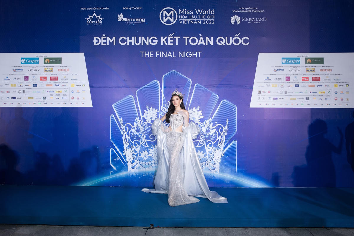 Đương kim Hoa hậu Hoà bình Quốc tế - Thuỳ Tiên kiêu kỳ trong đầm ánh bạc đính kết tỉ mỉ với phần tà bay bổng. Thời gian qua, cô chiếm cảm tình của khán giả Việt với chuyến thiện nguyện tại châu Phi và thực hiện nhiều chuyến công tác trong nước.