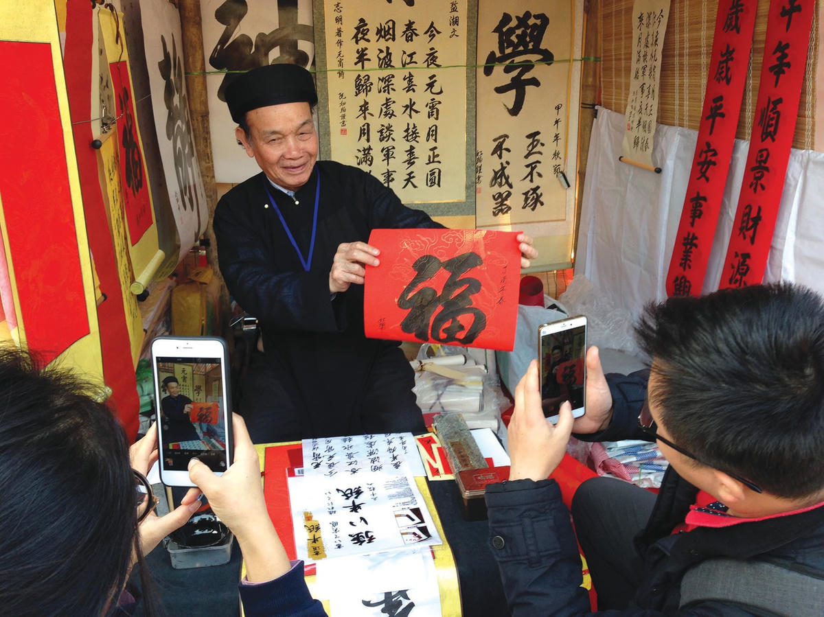 Ông đồ ngày nay cũng đã quen với việc được người xin chữ chụp ảnh đưa lên mạng xã hội.  