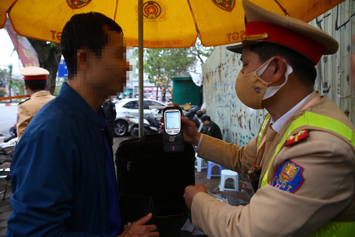 Cảnh sát giao thông kiểm tra nồng độ cồn của một tài xế tham gia giao thông.