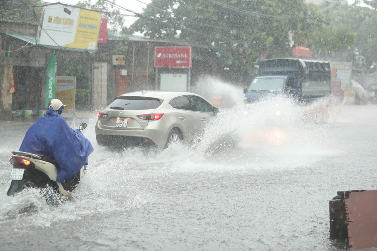 [ẢNH] Hà Nội mưa 'trắng trời', nhiều người phải dắt xe vì ngập nặng