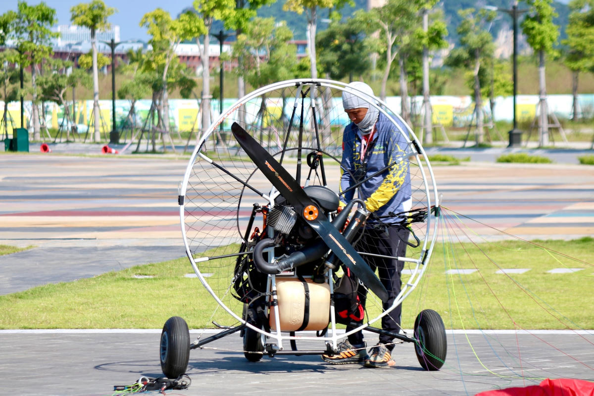 Phi công kiểm tra động cơ dù lượn trước khi bay.